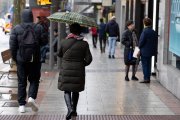 Archivo - Personas con paraguas bajo la lluvia en Madrid.