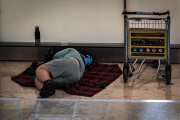 Archivo - Una persona duerme en la T4 del Aeropuerto Adolfo Suárez-Madrid Barajas, a 12 de mayo de 2025, en Madrid (España). 