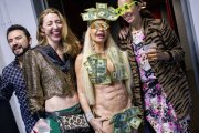 Leticia Sabater, en uno de sus shows, luce un look extravagante con billetes falsos y gafas de símbolo dólar, reforzando su imagen kitsch y provocadora ante un público entregado.
