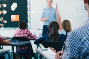 Un profesor atiende las dudas de sus alumnos en clase.