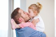 Un padre besando a su hija en la boca
