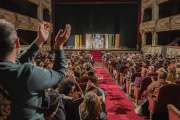 El patio de butacas de un teatro aplaude tras una función.