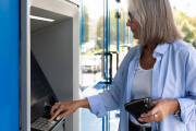 Una mujer utiliza un cajero automático para retirar dinero en efectivo, una práctica habitual que sigue generando dudas legales sobre los límites del efectivo en España.