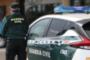 Un agente de la Guardia Civil, de espaldas, junto a un vehículo oficial (Foto de ARCHIVO)