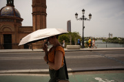 Una mujer se protege del sol en Sevilla.