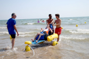 Iván prueba el nuevo sillón ergonómico adaptado durante la presentación del proyecto en la playa de El Cabanyal.