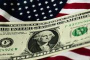 Billete de dólar sobre una bandera de Estados Unidos (EE.UU.).