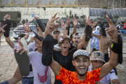 Varios jóvenes saludan tras su entrada desde Marruecos en Ceuta.