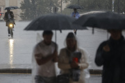 Varias personas con paraguas bajo la lluvia, en imagen de archivo