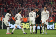 MUNICH, GERMANY - APRIL 15: Vinicius Junior, Arda Gueler, Kylian Mbappe and Jude Bellingham of Real Madrid interact with referee Slavko Vincic after he showed a red card to Eduardo Camavinga of Real Madrid following a second yellow card during the UEFA Champions League 2025/26 Quarter-Final Second Leg match between FC Bayern München and Real Madrid CF at Football Arena Munich on April 15, 2026 in Munich, Germany. (Photo by Alex Grimm/Getty Images)
