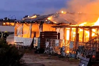 Dos bomberos atacando el fuego del chiringuito de El Palmar calcinado tras el incendio.
CONSORCIO DE BOMBEROS
22/7/2024