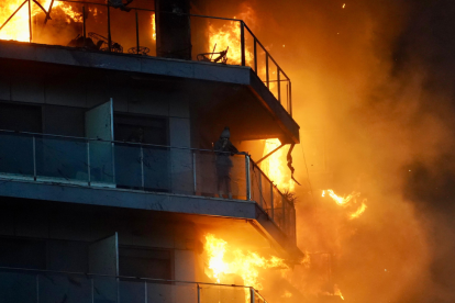 Una persona en un balcón del edificio en llamas, en el barrio de Campanar