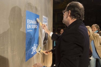 Rajoy en la pegada de carteles.