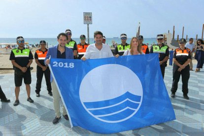 El alcalde sostiene la bandera azul junto al edil de Infraestructuras Israel Cortés y la concejal de Turismo Mari Carmen de España.