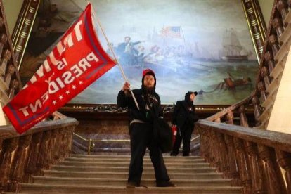 Un seguidor de Trump agita una bandera dentro del Congreso.