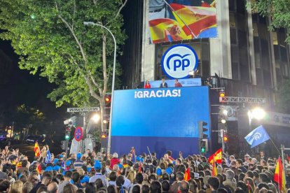 Una multitud llena la calle Génova frente a la sede del PP para celebrar la victoria electoral