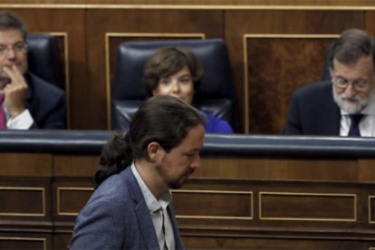 Iglesias pasa por delante del escaño de Rajoy durante el debate.