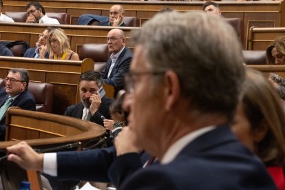 El líder de VOX, Santiago Abascal, habla por teléfono durante un pleno extraordinario en el Congreso de los Diputados.