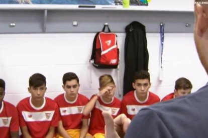 Los jugadores del Sevilla F.C. escuchan atentos al entrenador.