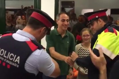 Dos mossos reciben una rosa en un colegio electoral que debían clausurar.