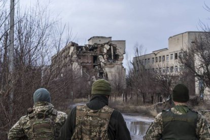 Soldados ucranianos, delante de edificios destrozados en la primera línea del frente en el Donbás. (Getty/Brendan Hoffman)