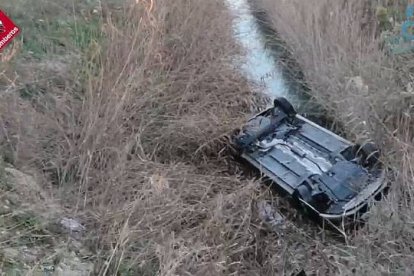 El vehículo ha quedado volcado boca abajo sumergido parcialmente en el agua de la acequia