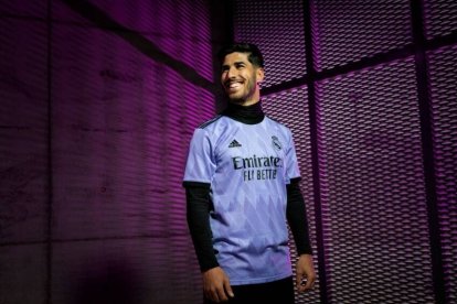 Asensio posa con una de las nuevas camisetas del Real Madrid.