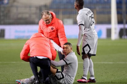 Mbappé, ayudado por los servicios médicos del PSG tras caer lesionado.