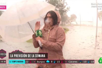 Carla Álvarez, durante su conexión en La Sexta y antes de perder el paraguas por el viento.