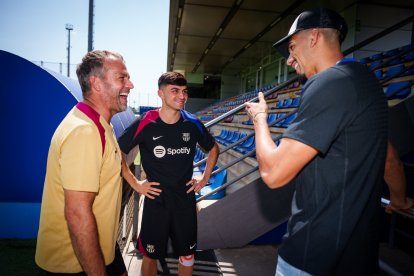 El entrenador del FC Barcelona, Hansi Flick, charla con sus jugadores Pedri y Ronald Araujo.