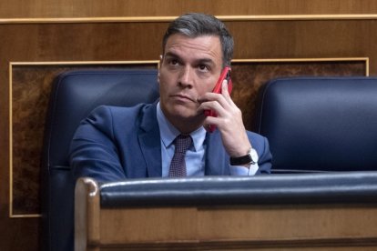 Pedro Sánchez habla por el teléfono en una sesión en el Congreso de los Diputados.