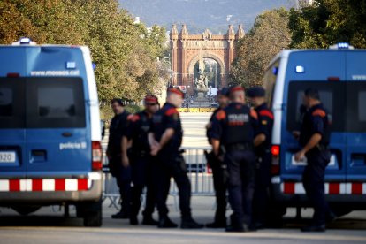 Agentes de los Mossos d' Esquadra y varias personas en las inmediaciones del Parlament de Cataluña.