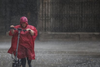 Una persona camina bajo la lluvia