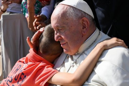 Un niño abraza al Papa Francisco en una audiencia de los miércoles en el Vaticano.