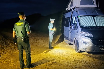 Agentes de la Guardia Civil junto a una de las autocaravanas desalojadas en Tarifa (Cádiz).