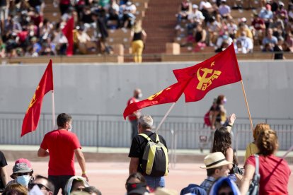 Varias personas sostienen banderas del PCE, en la fiesta del centenario del PCE