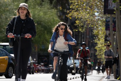 Usuarios de bicicleta y patinete eléctrico circulan por Barcelona.