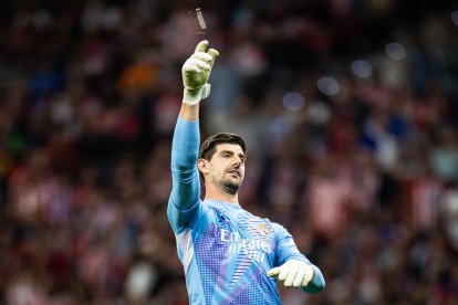 Courtois, recibiendo uno de los objetos que cayó al césped del Metropolitano el pasado domingo.