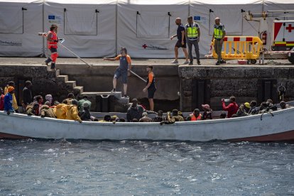 Los equipos de emergencias ayudan a desembarcar a varios migrantes en el puerto de La Restinga, en El Hierro.