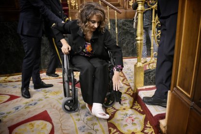 La vicepresidenta primera y ministra de Hacienda, María Jesús Montero, llega en silla de ruedas a la sesión de control al Gobierno.