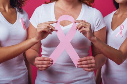 Mujeres con Cáncer de Mama sujetan el lazo rosa que representa la enfermedad.