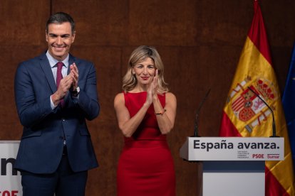 Pedro Sánchez y Yolanda Díaz aplauden tras firmar un acuerdo para un Gobierno de coalición progresista.