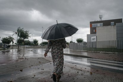 Una mujer camina bajo de la lluvia