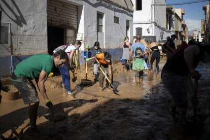 Varios voluntarios retirando barro en Valencia