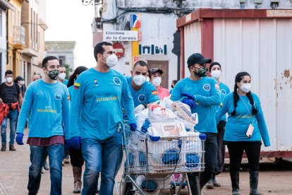 Varios voluntarios llevan productos donados, en Lloc Nou, a 5 de noviembre de 2024, en Valencia.