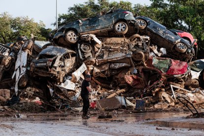 Varias personas limpian entre coches amontonados en Alfafar, a 5 de noviembre de 2024, en Valencia.