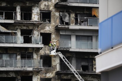 Bomberos trabajan en la limpieza del edificio incendiado, en el barrio de Campanar, a 27 de febrero de 2024, en Valencia.