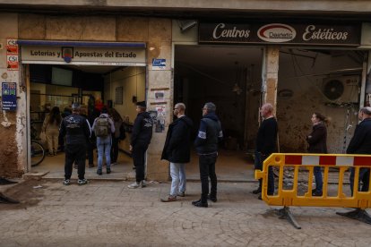 Varias personas hacen cola en una administración de lotería de Paiporta.