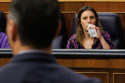 Irene Montero bebe agua en el Congreso. En primer plano, Pedro Sánchez, de espaldas.