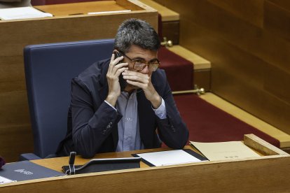 El presidente de la Generalitat valenciana, Carlos Mazón, habla por teléfono móvil